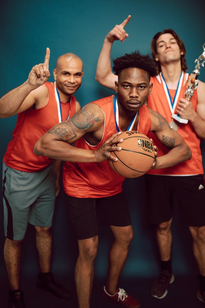 Basketball Players Wearing Uniform Holding Ball and Trophy